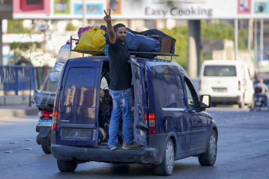 가재 도구를 차에 싣고 피난을 떠나는 레바논 주민이 '승리의 V'를 그리고 있습니다. AP 연합뉴스